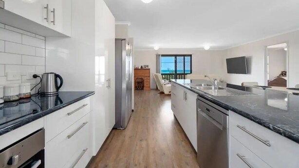 A modern kitchen with white cabinets, a black countertop, and stainless steel appliances. - Escape to Paradise - Beach views 5bedrooms, 2 Kitchens, 2 Living, 2 Bathrooms (Paradise Beach)