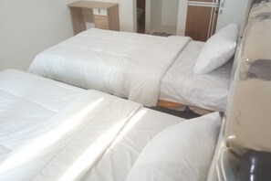 Two single beds with white bedding, a nightstand and mirror.