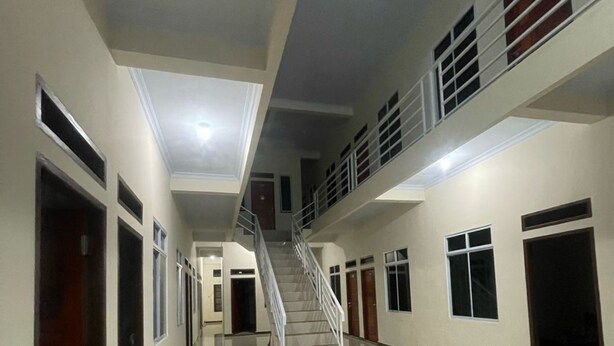 A multi-level interior with a central staircase, multiple doors, and a polished floor. - Hotel O Pondok Ibu SyariahNearEco Edu Park (Pekanbaru)