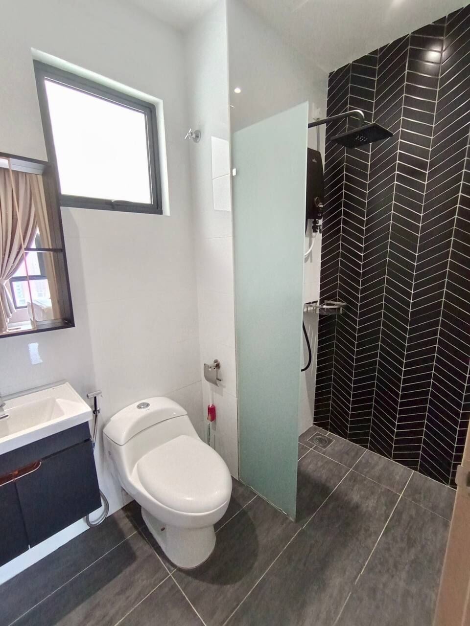 A modern bathroom with a toilet, sink, and shower.