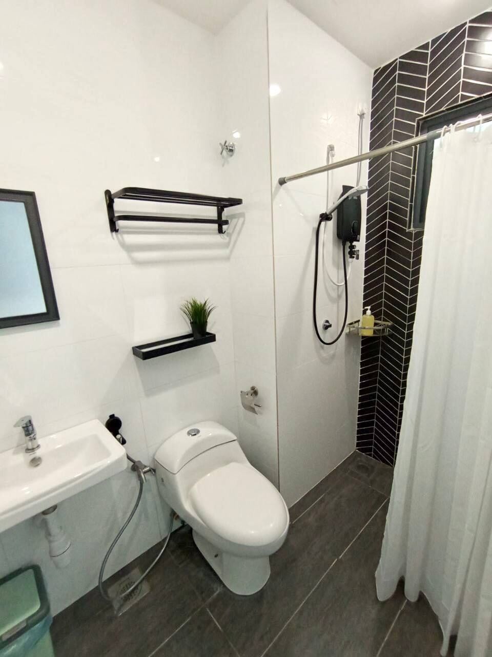 A modern bathroom with a white toilet, a sink, and a shower area.
