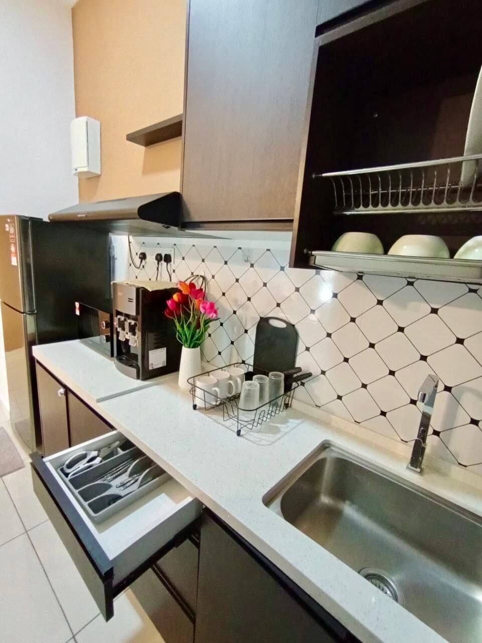 A modern kitchen with a stainless steel sink, a built-in oven, and a microwave.