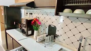 A modern kitchen with a stainless steel sink, a built-in oven, and a microwave.