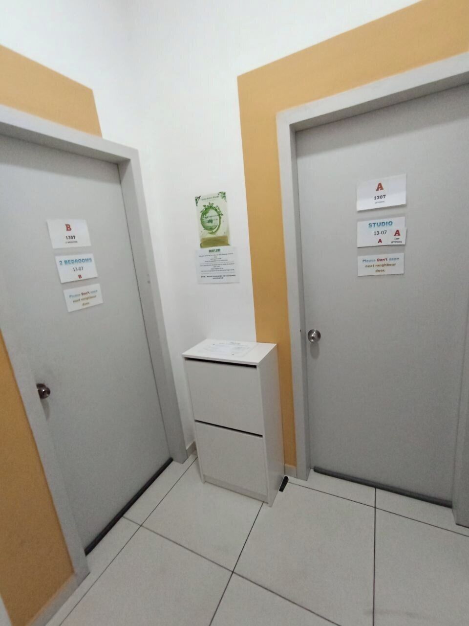 A hallway with two doors, each marked with a room number and a sign indicating the number of bedrooms.