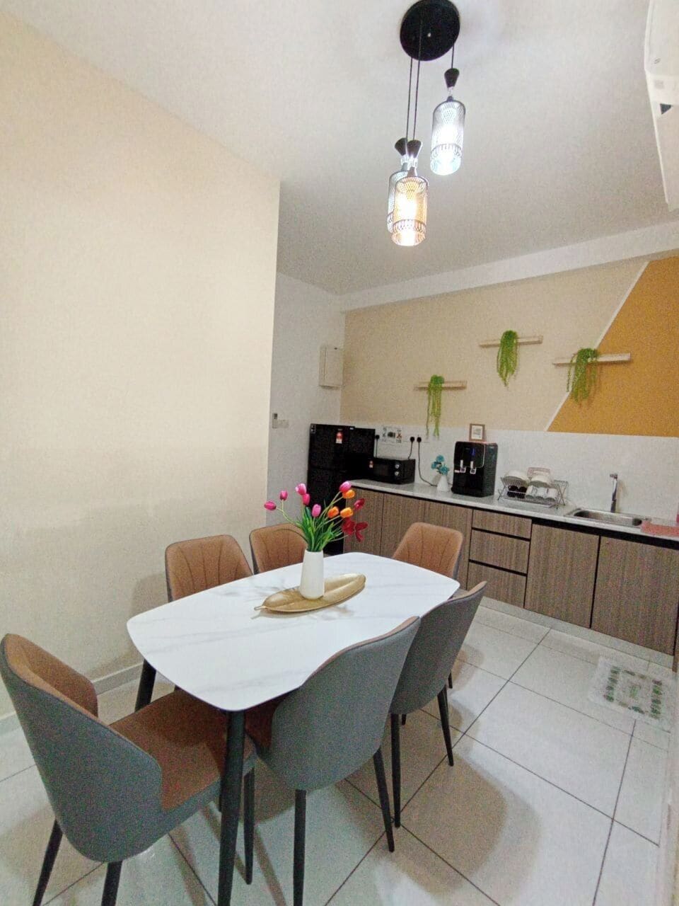 A dining area with a table, chairs, and a vase of flowers.