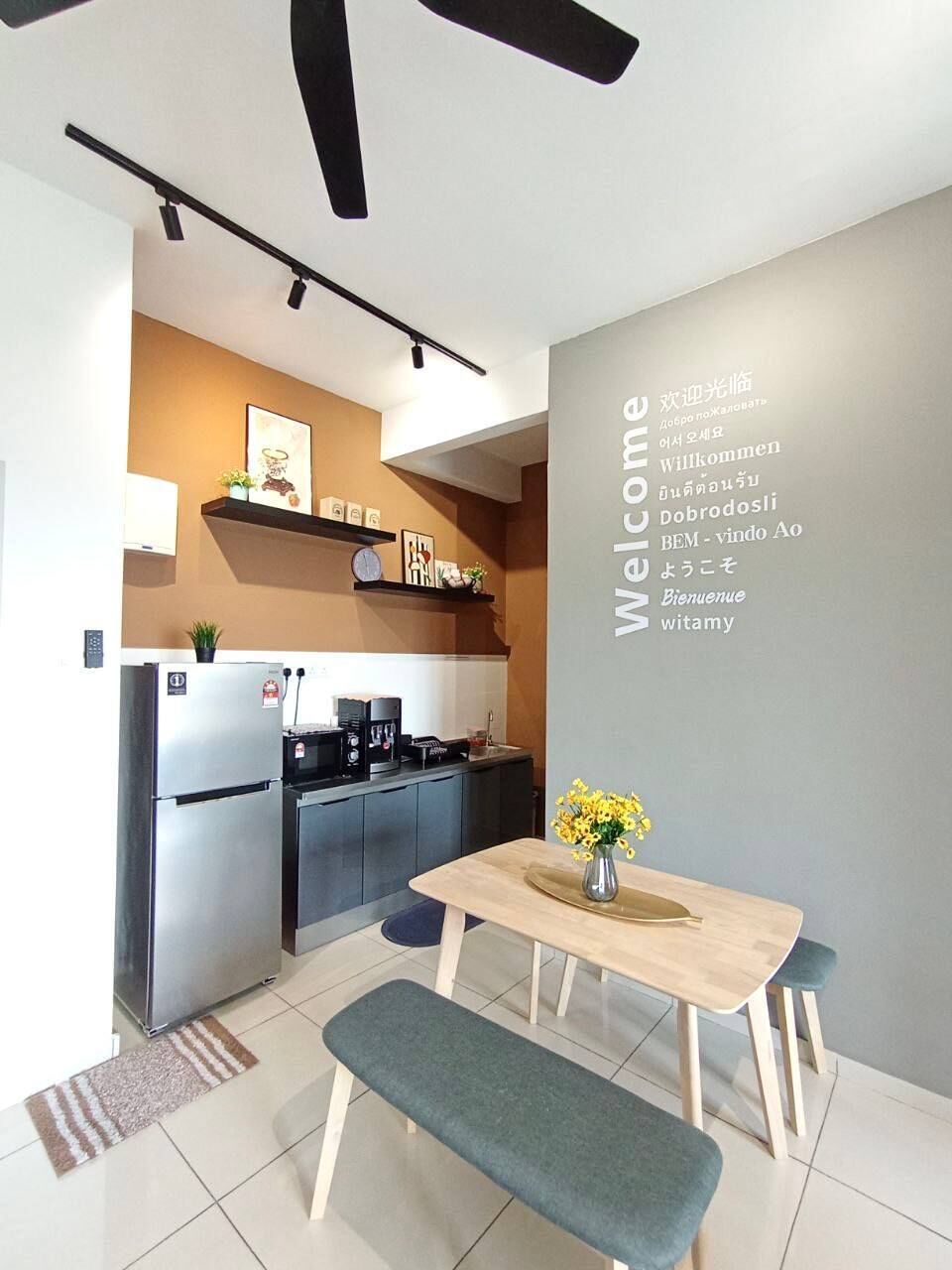 A modern kitchen with a built-in fridge, a coffee machine, and a dining area with a bench and table.