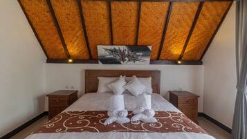 A neatly made bed with a brown patterned bedspread, two bedside tables, and a wooden headboard.