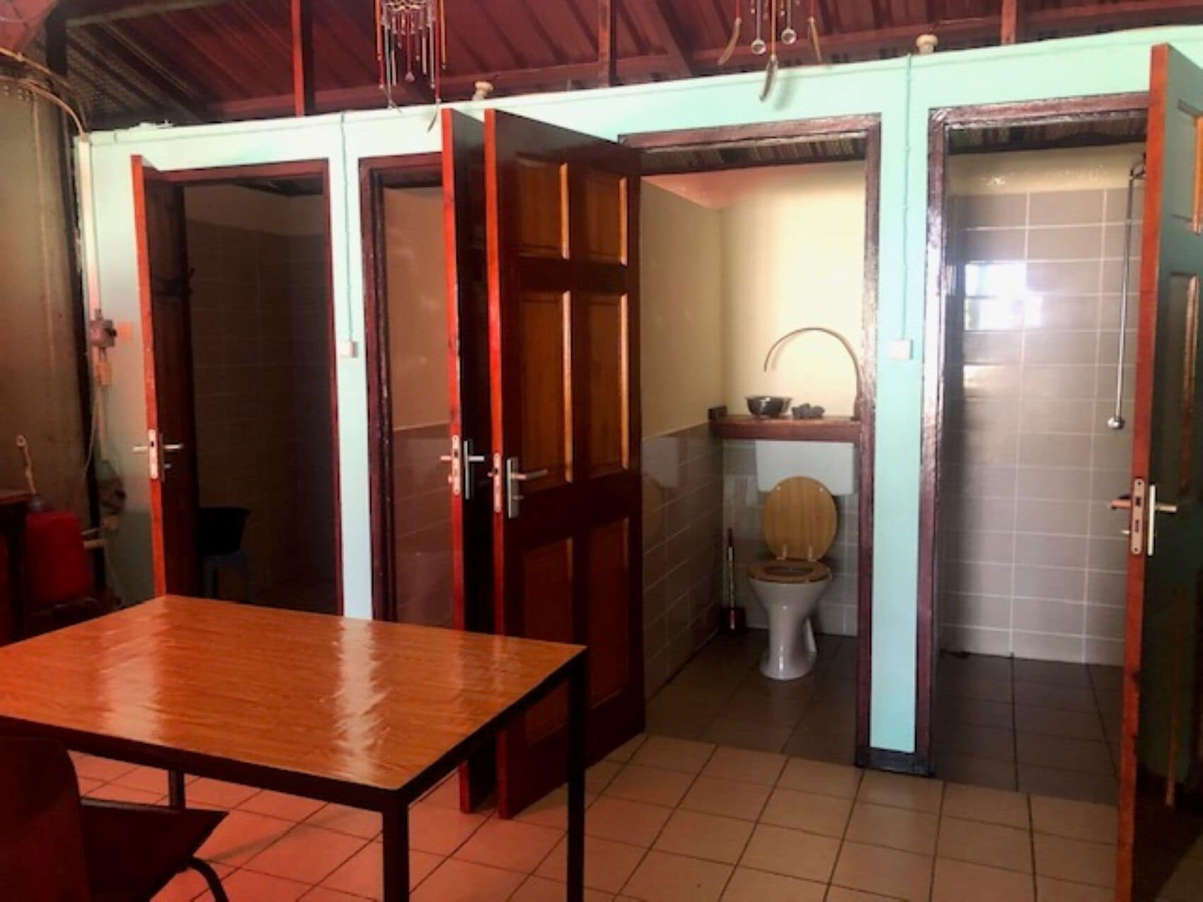 A compact room with a wooden table, a toilet, and a sink.