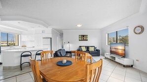 A modern apartment with a dining area, living room, and kitchen.