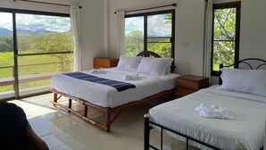 Habitación de hotel con dos camas, ventanas amplias y vistas al exterior.