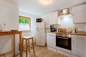 Una cocina moderna con refrigerador, microondas, horno y encimera de madera.