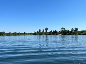 Un lac paisible, avec des bateaux et une rive bordée d’arbres.