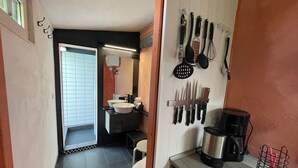 A modern bathroom with a sink, mirror, and a wall-mounted utensil rack. - Holiday Home 'Teehaus' (Saal)