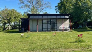 A small, single-story building with a flat roof, large windows, and a door. - Holiday Home 'Teehaus' (Saal)