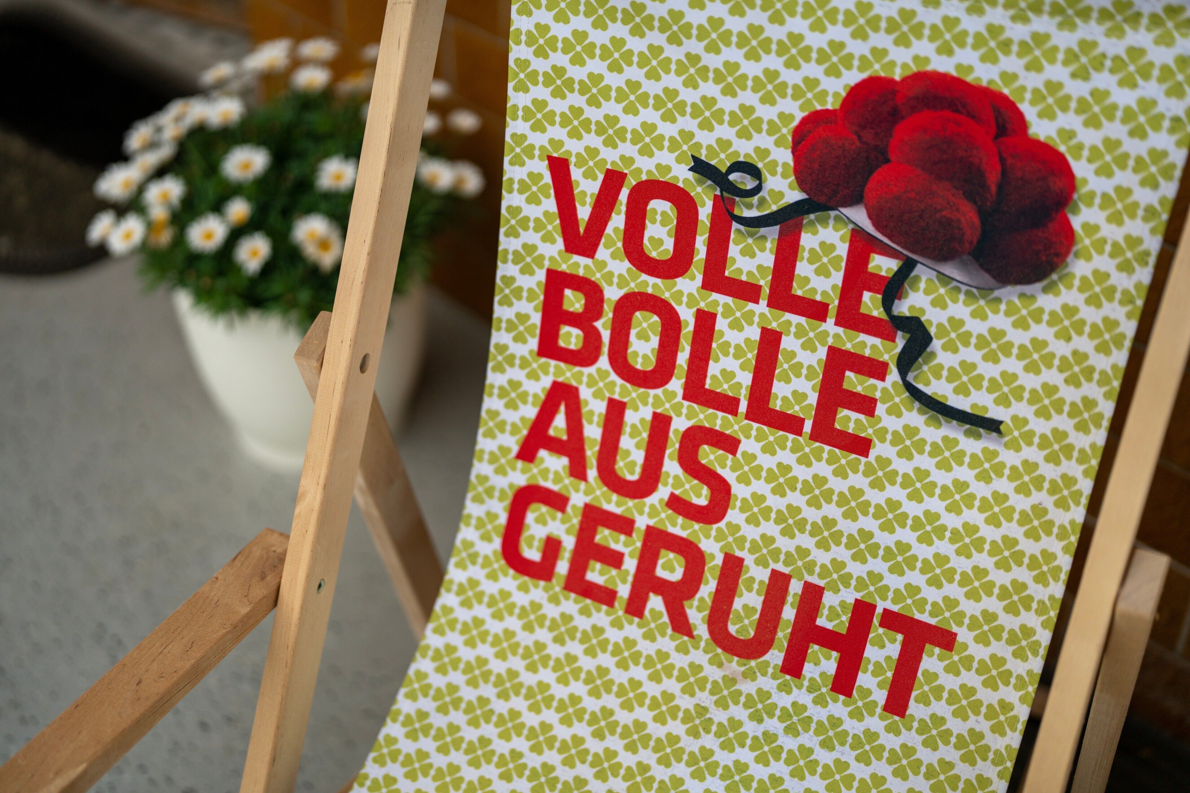 A sign with text and a red flower decoration.