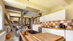 A kitchen with a wooden table, white cabinets, and a checkered backsplash. - Apartment 'Altes Pfarrhaus - Durchblick' with Private Garden and Wi-Fi (Hüttenrode)