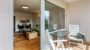 Un intérieur moderne comprenant un coin repas, un canapé et une porte vitrée donnant sur un espace extérieur.