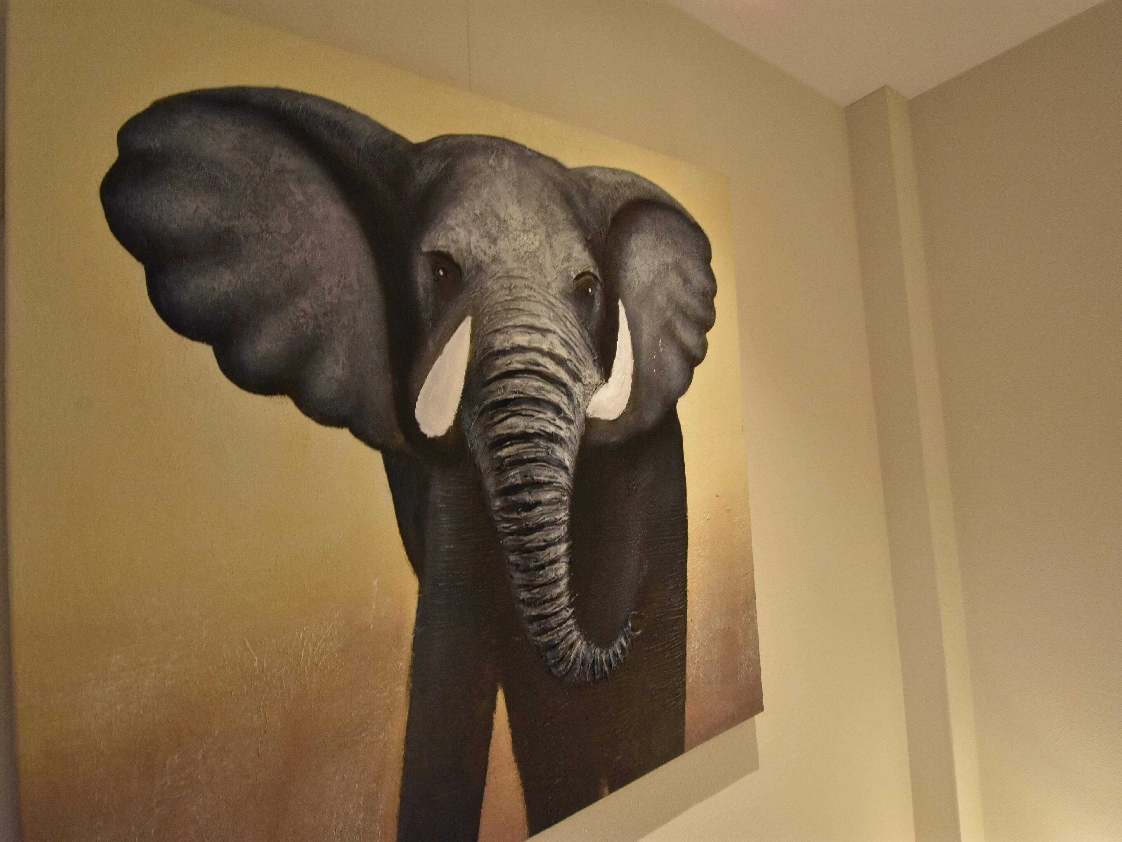 A large elephant sculpture mounted on a wall.