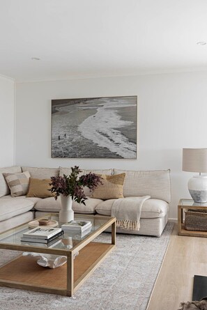 Ein Wohnzimmer mit einer Couch, einem Couchtisch, einer Lampe und einem Wandbild.