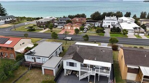 Un área residencial costera con casas, una carretera y vistas al mar.