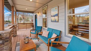 Un espace extérieur abrité, aménagé avec du mobilier en bois et doté d’un mur en pierre.