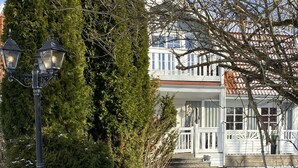 Un sendero cubierto de nieve que lleva a un edificio blanco con techo rojo.