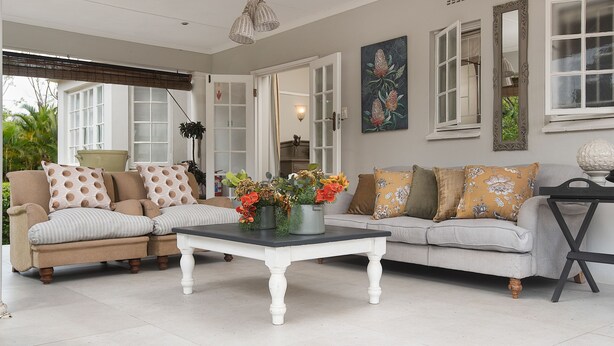 A spacious living room with two sofas, a coffee table, and a potted plant. - Isoyi on the Mill (Durban North)