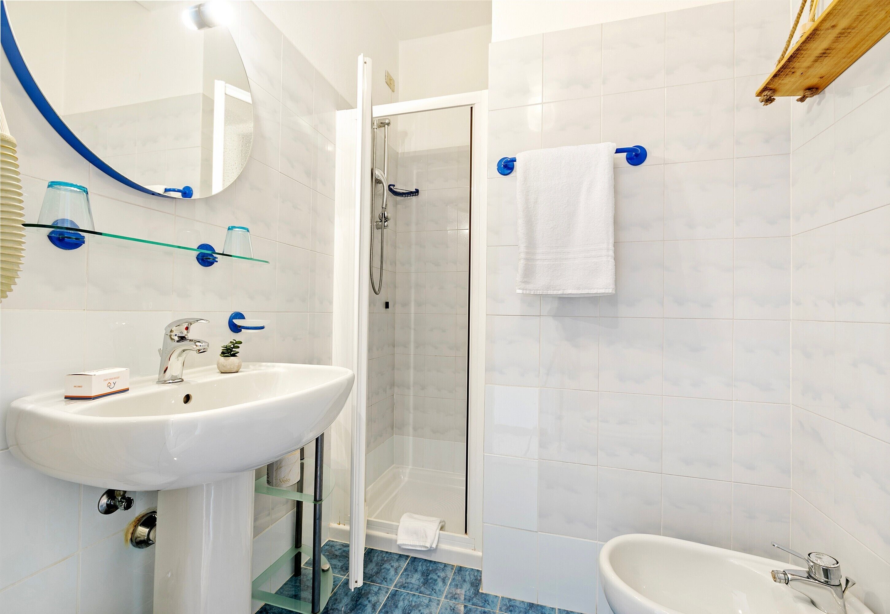A modern bathroom with a white sink, a glass shower enclosure, and a white bathtub.