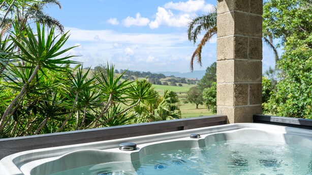 Un jacuzzi con vista despejada a un paisaje exuberante al fondo.
