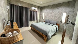 A modern bedroom with a bed, a desk, and a chair. There is a basket on the desk and a window with curtains. - Samanta By The Hill (Koh Lan)