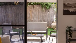 A room with a view of a backyard patio area, including a table, chairs, and a wooden fence. - Serenity by the Sea – Poleg Villa by Sea N' Rent (Netanya)