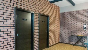 Two doors with a brick wall and a wooden floor. - Suria Suites at Tanah Rata (Tanah Rata)
