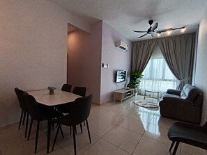 A modern living room with a dining area, a sofa, a TV, and a ceiling fan.