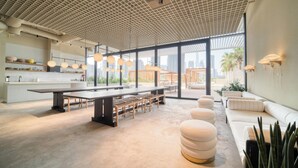 A modern interior with a large dining table, seating, and a view of the city. - Prime Location, Pristine Studio in Business Bay (Dubai)