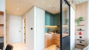 A modern kitchen with a built-in oven, a sink, and a countertop with various kitchen items. - Prime Location, Pristine Studio in Business Bay (Dubai)