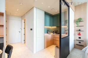 A modern kitchen with a built-in oven, a sink, and a countertop with various kitchen items. - Prime Location, Pristine Studio in Business Bay (Dubai)