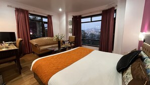 Una habitación de hotel con cama, sofá, escritorio y televisión.