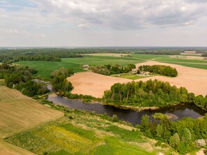An aerial view of a rural landscape with fields, a river, and scattered buildings. - Guest house Sidrabi (Druva)