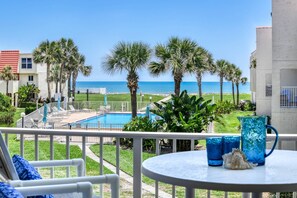 A balcony with a pool, palm trees, and a view of the ocean. - Oceanfront! Renovated! Pool & Ocean Views! Steps to Beach, Shops, Restaurants! $300 in Free Tickets! (St. Augustine)