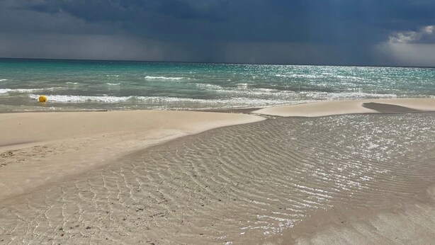 A beach with clear water, a yellow ball, and a cloudy sky. - Sea view cottage (San Pietro In Bevagna)
