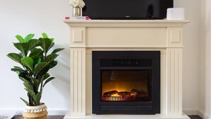 A fireplace with a TV on top, a plant to the left, and a white wall. - Old Town Pearl: Two Bedromms - Wasching Machine - Parking (Pirna)