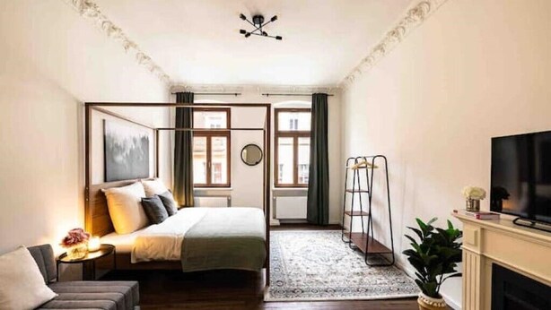 A modern bedroom with a bed, a sofa, a TV, and a fireplace. - Old Town Pearl: Two Bedromms - Wasching Machine - Parking (Pirna)