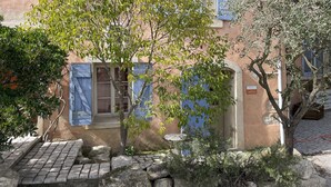 A rustic building with a tiled roof, stone walls, and blue shutters. - In Provence Hôtel (Venelles)