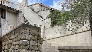 A stone staircase leading to a building entrance, with a 'no entry' sign above. - In Provence Hôtel (Venelles)
