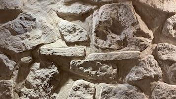 A stone wall with a recessed ceiling light.