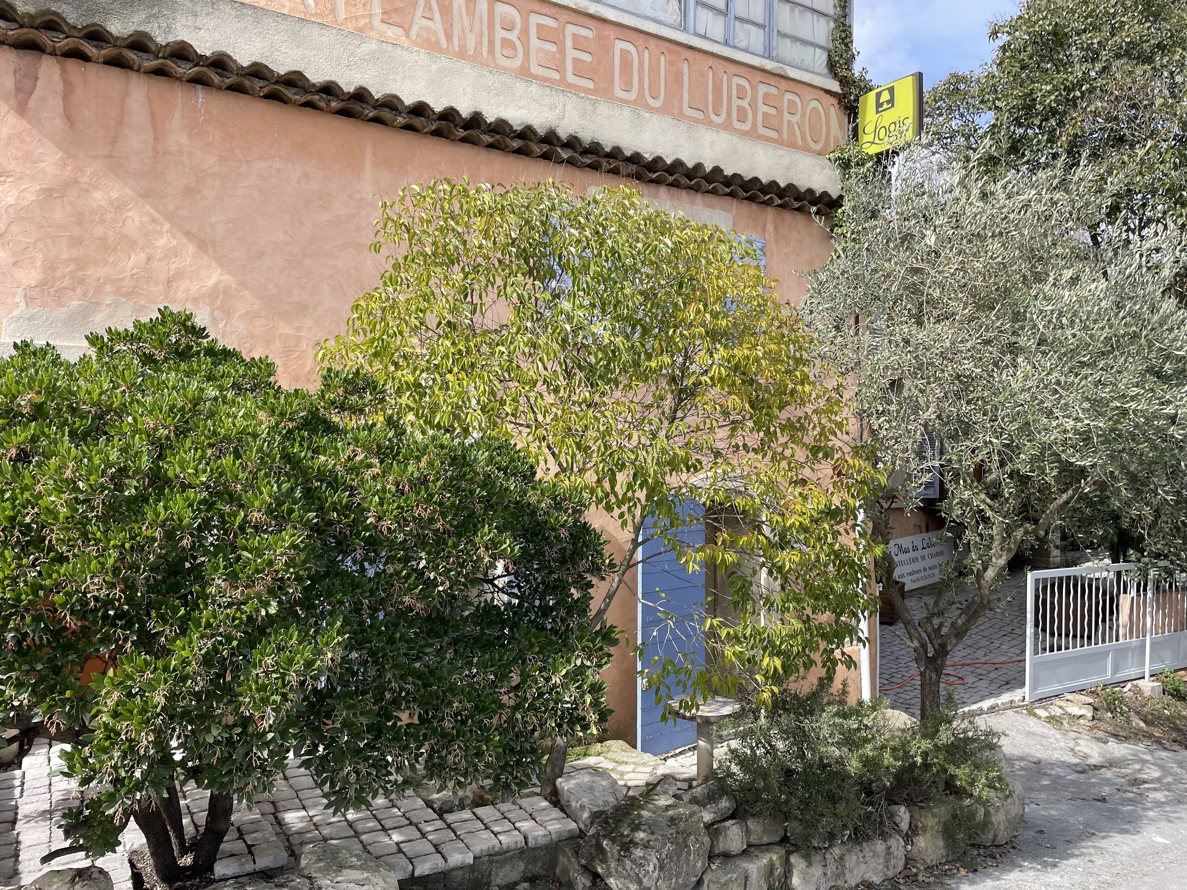 Un bâtiment sur lequel on peut lire l’inscription « LAMBEE DU LUBERON », ainsi qu’un panneau jaune sur lequel est écrit « LOUIS ».