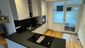 A modern kitchen with a black countertop, white cabinets, and a built-in oven.