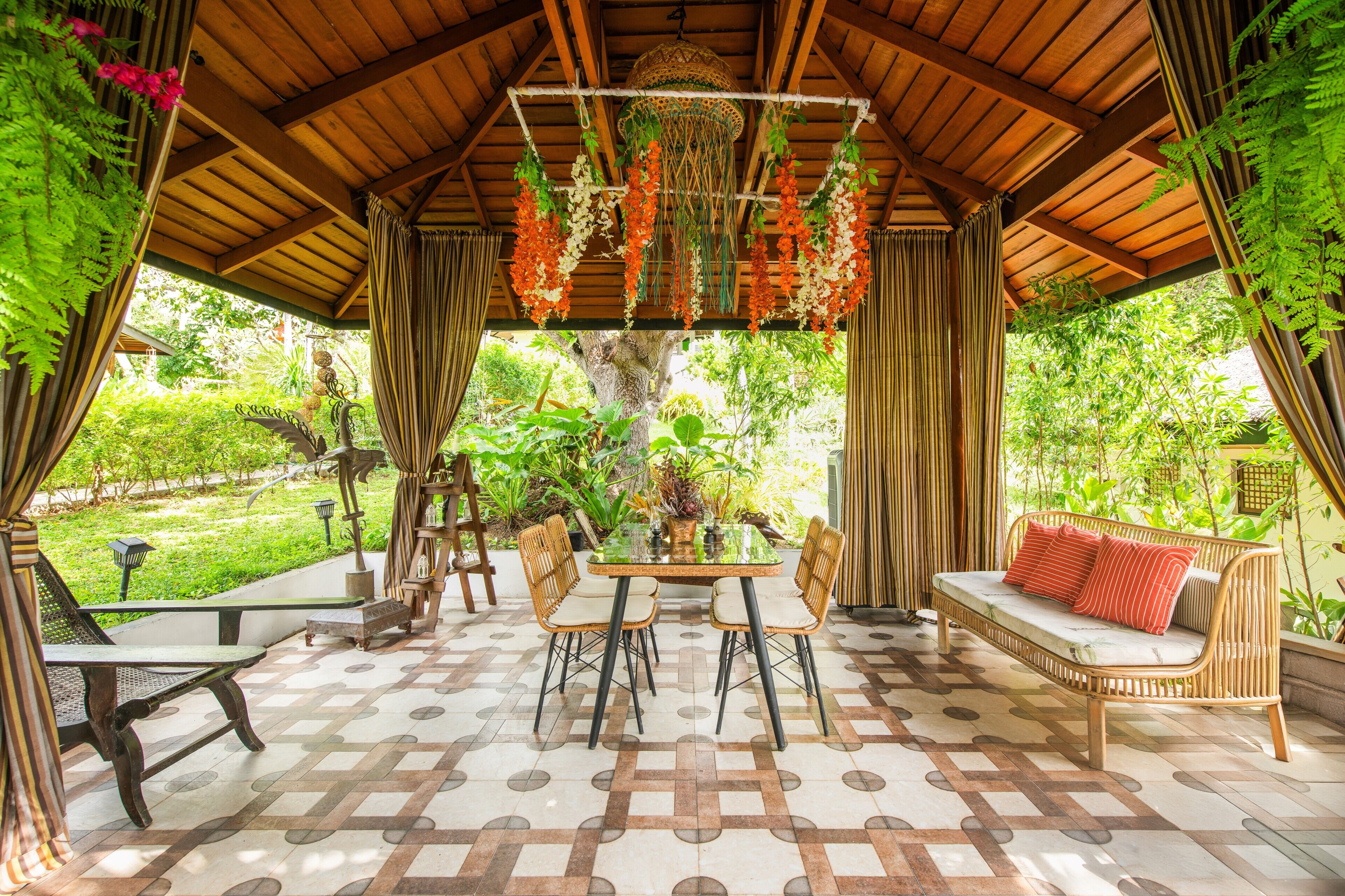Un espace extérieur abrité, aménagé avec une table, des chaises et un canapé.