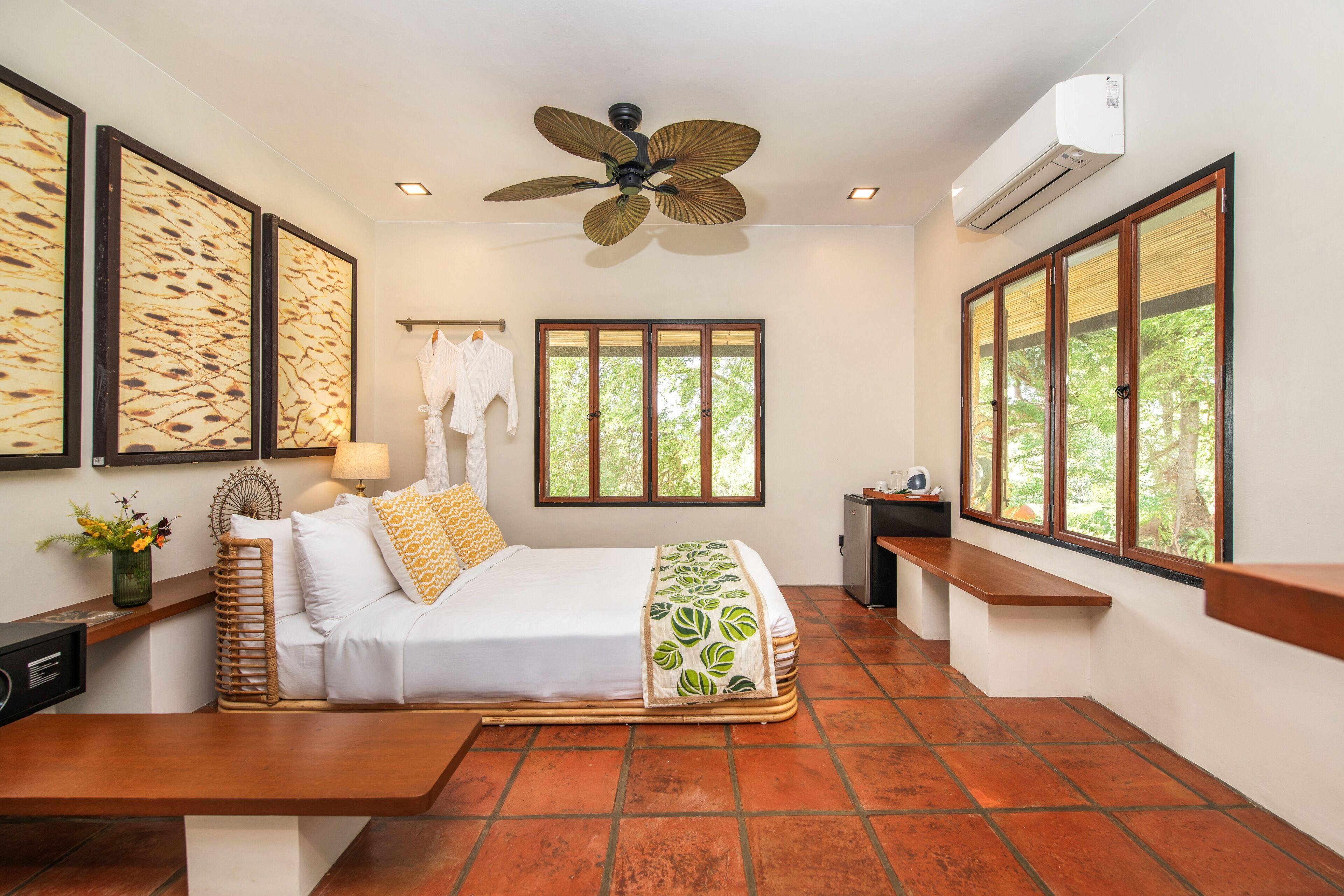 A room with a bed, a ceiling fan, a window, and a wall-mounted air conditioner.