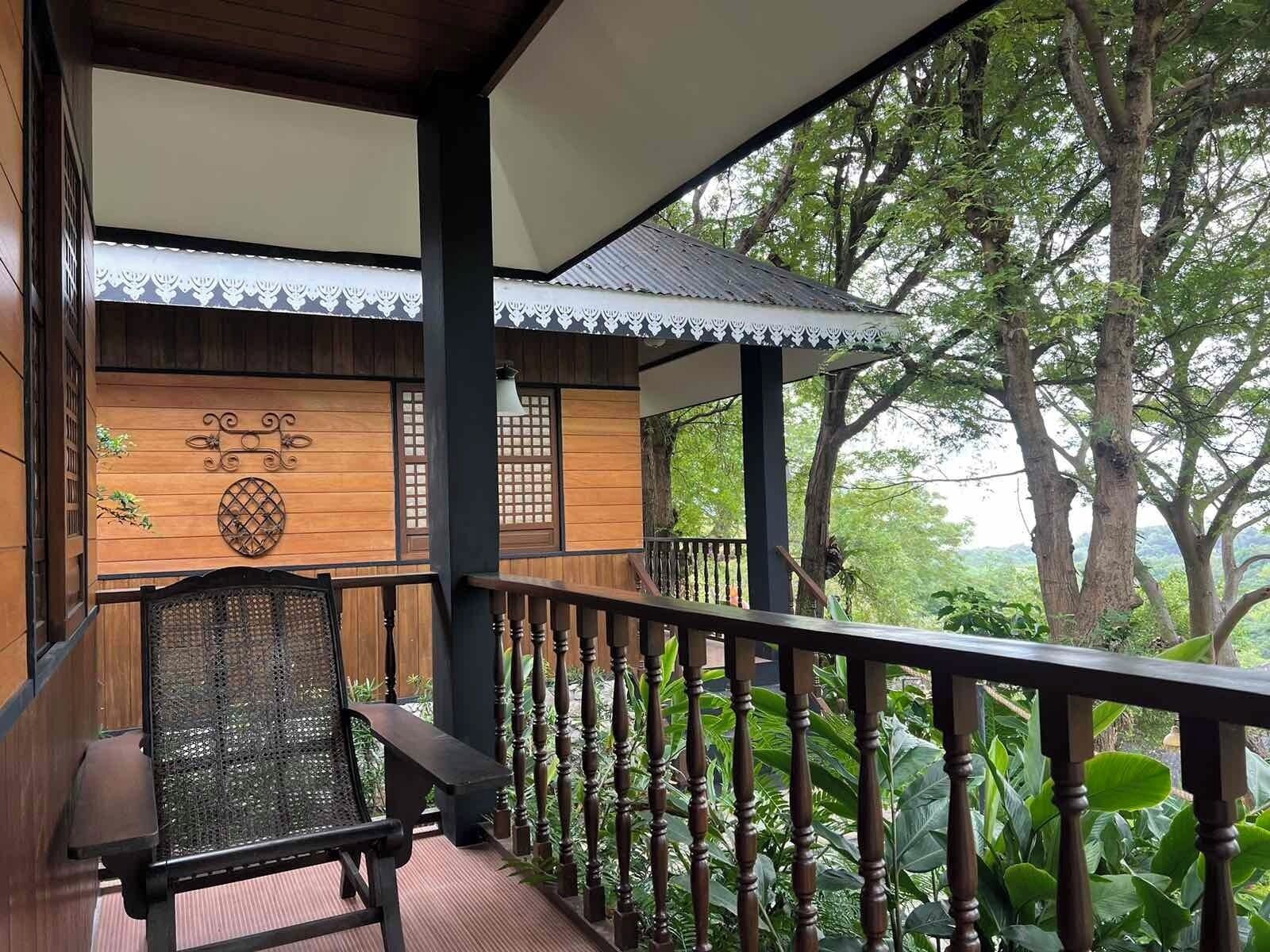 A wooden structure with a balcony, a bench, and a railing.